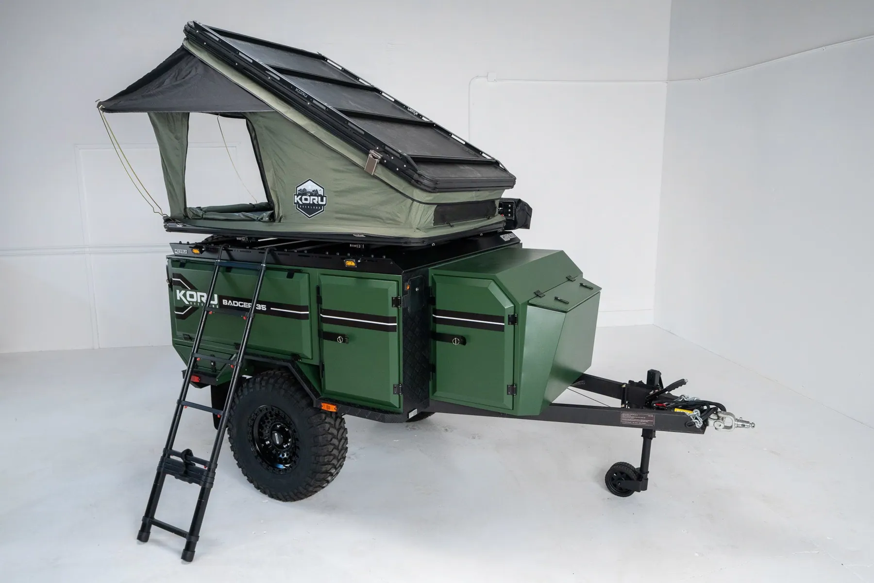 Green Koru Badger overland trailer with the rooftop tent open