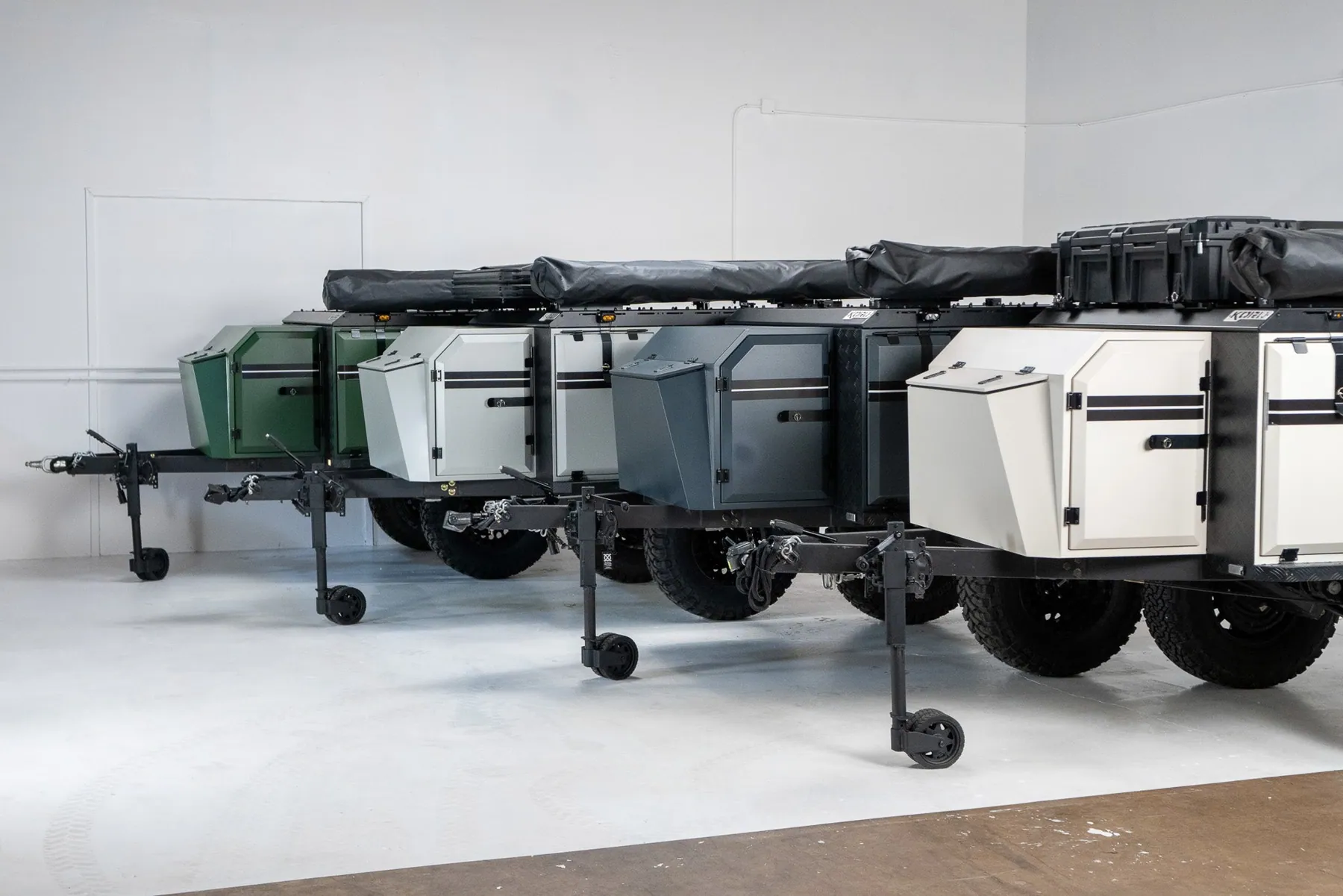 A row of Koru Badger 35 overland trailers in the Addison, Texas showroom