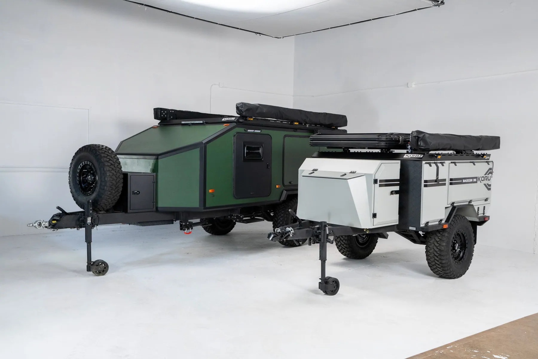 Green and white Koru Badger off-road trailers side by side